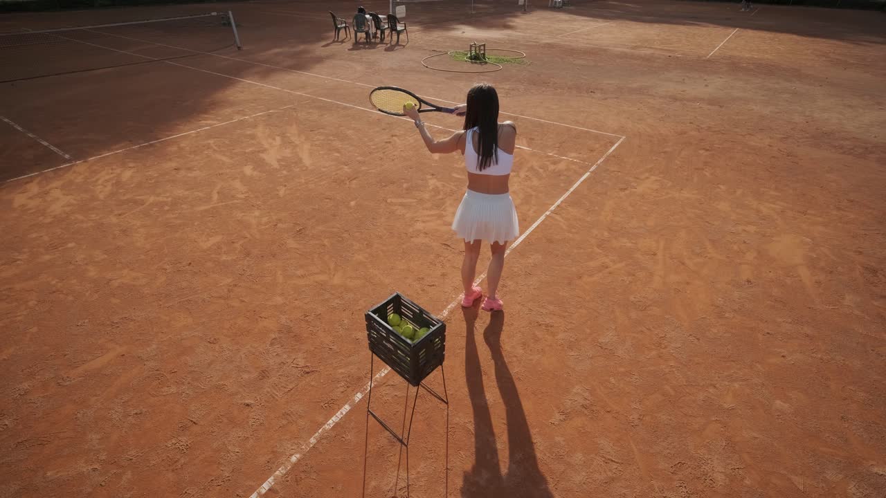 아름다운 테니스 소녀가 야외 코트에서 을 연습하고 있습니다.