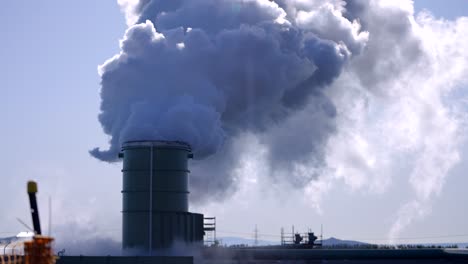 geothermal plants burning fossil fuels to produce electricity, cimney discharging dense smoke, contaminated gas in the atmosphere, global warming