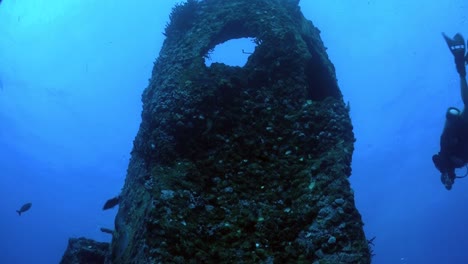 Ein-Taucher-Schwimmt-Aus-Einem-Niedrigen-Winkel-Um-Ein-Schiffswrack-Herum