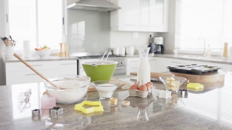 General view of kitchen with baking ingredients and equipment on countertop, slow motion