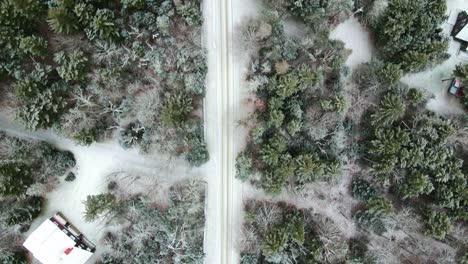 a drone shot of a road that has snow on it, showing the potential hazards cars and trucks might face if delivering in the winter time