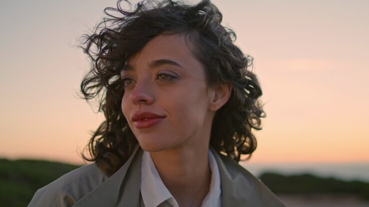 Closeup girl raising eyes head at blurred evening sky. Smiling woman resting