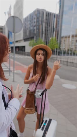 two women discussing on the city street