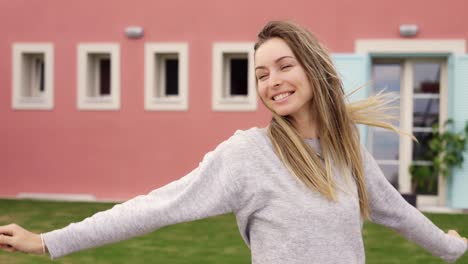 satisfied lady jumping with keys of new apartment in her hand outside new home