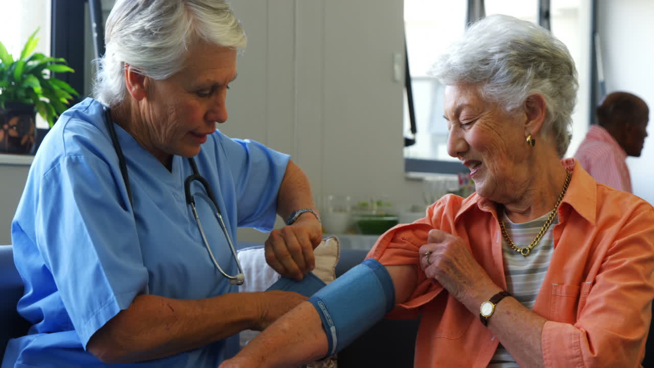 Female doctor checking blood pressure of senior woman 4k