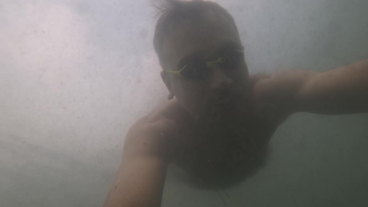 Vista subacquea al rallentatore del braccio di un nuotatore che si muove attraverso acqua torbida, Costa Azzurra, Francia