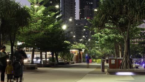 people walking through a lively urban park at night