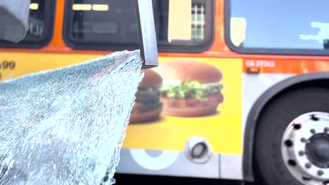 a broken glass payne lays on the ground next to the busy street of wilshire blvd during rush hour with the famous wiltern theater in the background as a bus drives into view