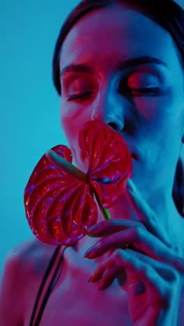 sensual portrait of a woman with red anthurium in neon light