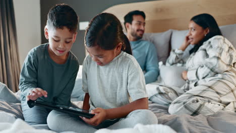 Tablet,-brother-and-sister-on-the-bed