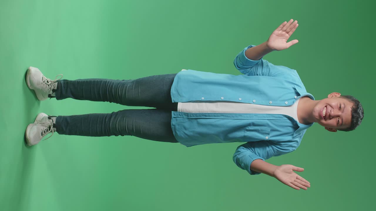 Full Body Of Young Asian Boy Opening His Eyes With Palms In The Green Screen Studio