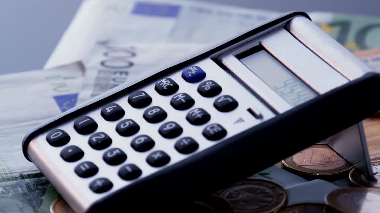 calculadora en las monedas y billetes de euro. tiro de rotación en bucle.