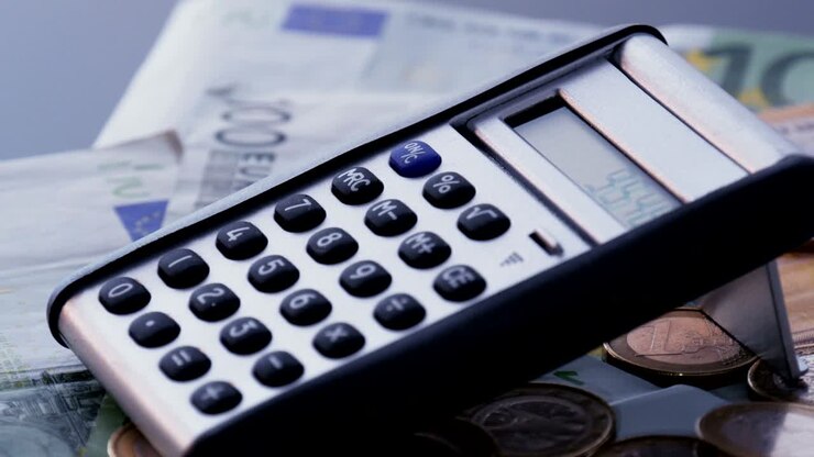 Calcolatrice su monete e banconote in euro. Ripresa con rotazione in loop