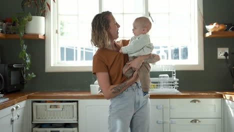 mother holding her baby in the kitchen