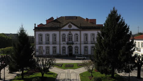 aerial shot flying backwards of city hall between trees, albergaria à velha