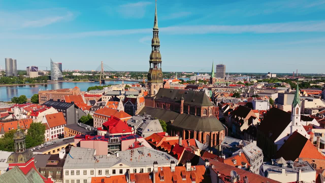 Establishing summer drone shot gliding forward above rooftops of Old Riga