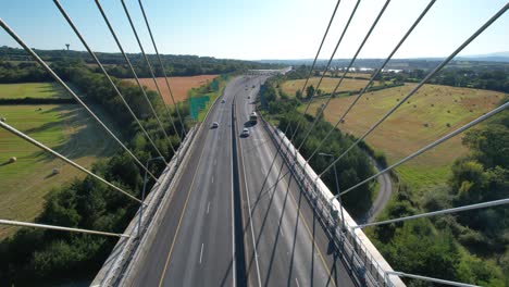 drone suspension bridge flowing traffic trucks and cars in waterford ireland summer eveningi