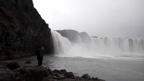 Tourist-Steht-Auf-Stein-In-Der-Nähe-Eines-Schäumenden-Wasserfalls