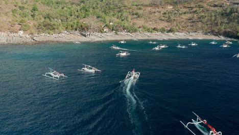 Traditional-Bali-fishing-boat-returning-to-shore,-Pantai-Kusambi-beach,-aerial