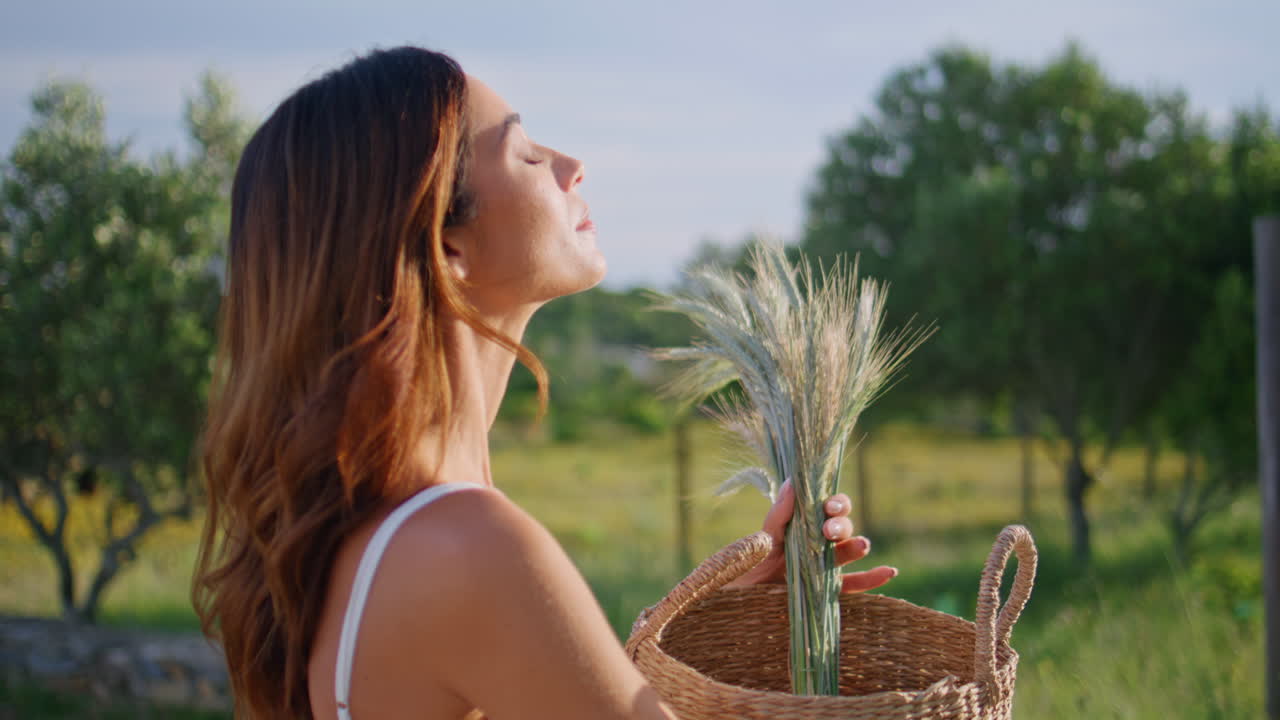 Sunny girl sniffing spikelets bouquet walking garden closeup. Lady feeling aroma