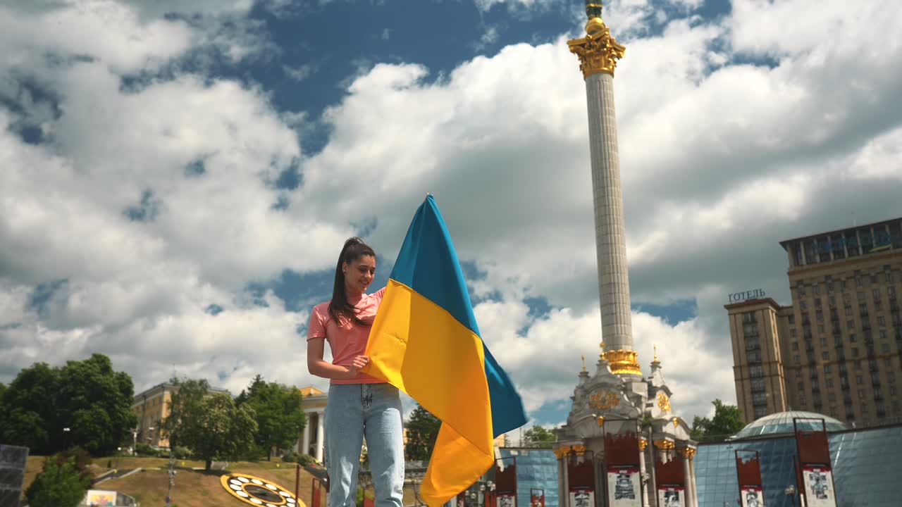도시 광장에서 우크라이나 국기를 들고 있는 여자