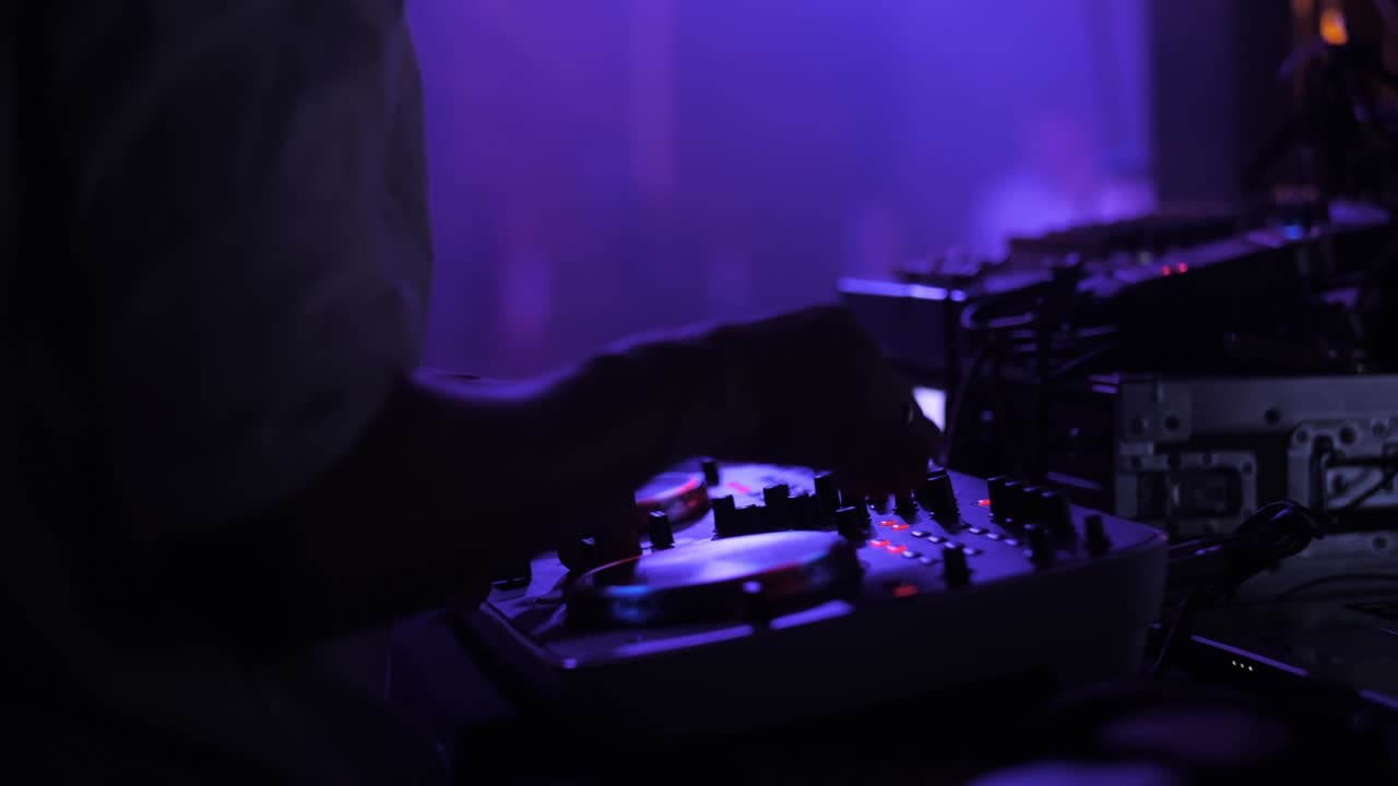dj tocando en la fiesta, manos de primer plano, luz de colores