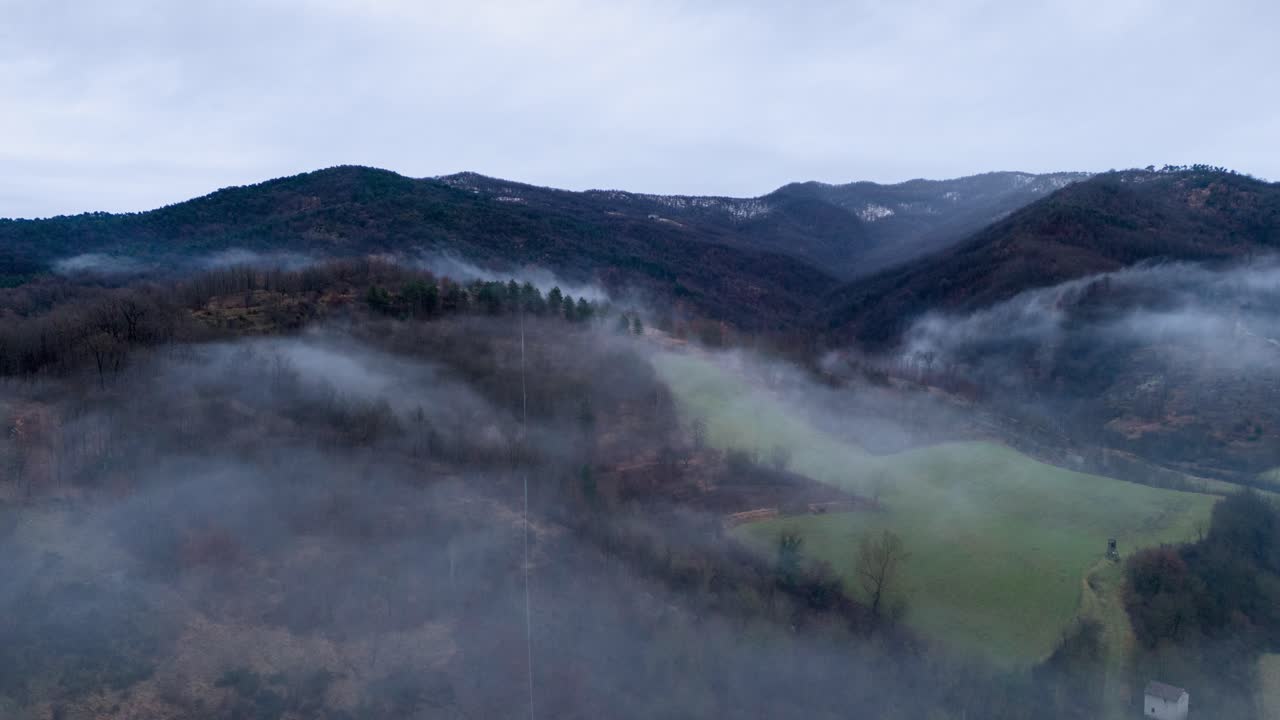 nubes de niebla sobre el paisaje rural montañoso debajo del cielo gris, time-lapse