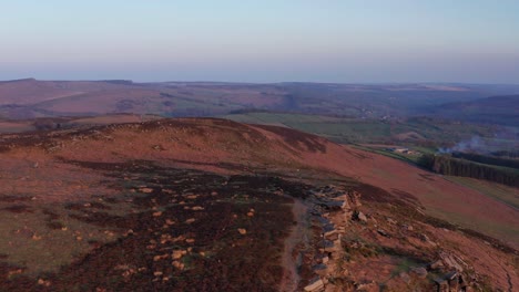 aerial drone tracking over cliffs at sunset in peak district united kingdom
