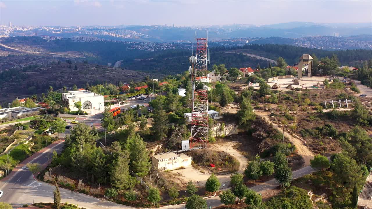 건물, 도로, 통신탑 이 있는 언덕 꼭대기 지역 의 공중 사진