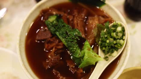 delicious noodle soup with meat and greens