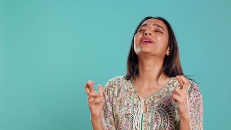 retrato de una mujer optimista cruzando los dedos, haciendo un deseo