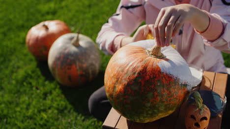 a child decorates a pumpkin - prepares festive decorations