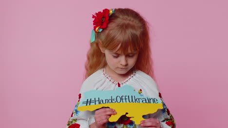 niña triste ucraniana que protesta contra el conflicto de guerra levanta la inscripción masaje manos fuera de ucrania