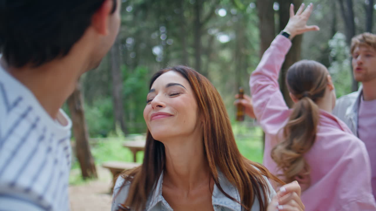 Young people dancing forest picnic having fun together at summer vacation