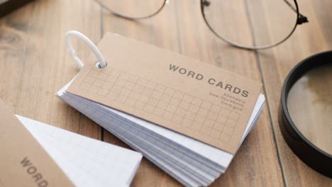 word cards and study supplies on a wooden desk