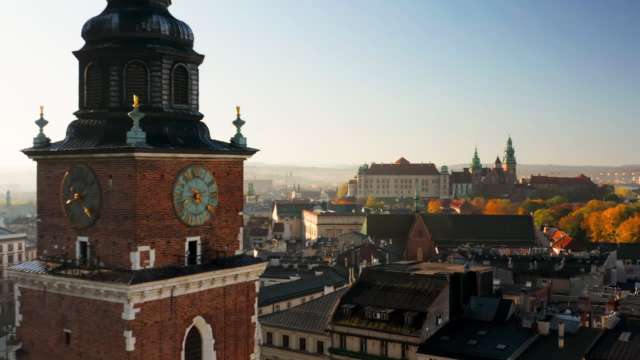 Panorama of Old Town in Krakow, Poland.View on clock on the town hall tower, the Wawel castle, Grodzka street and tenement houses with autumn colors at morning