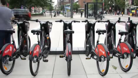 bike sharing experience: a dynamic interaction with the bike rental station in an urban setting showing people engaging with bicycles and commuting in a busy environment