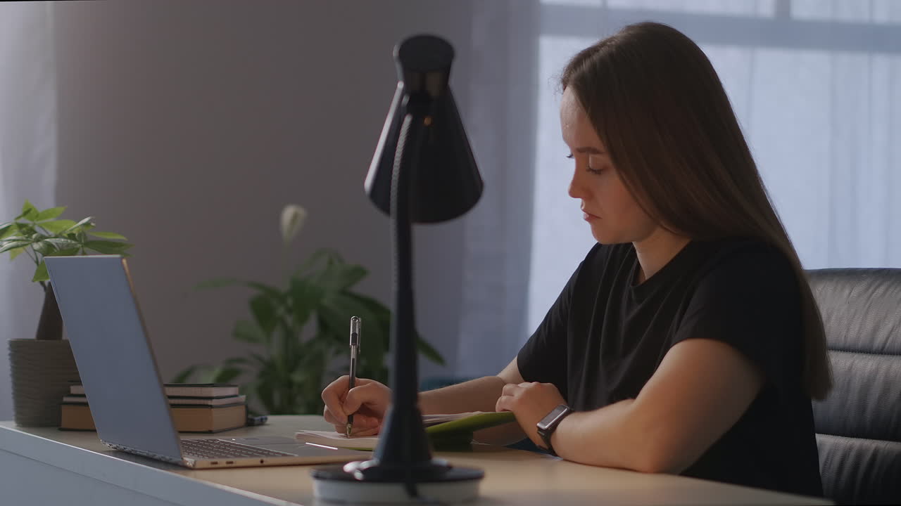 educación en línea durante el bloqueo y el aislamiento en la pandemia de coronavirus mujer está viendo una conferencia distante en la pantalla de la computadora portátil sentada en casa por la noche