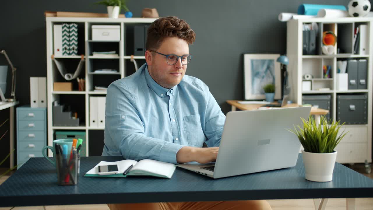 Serious businessperson handsome guy typing using laptop computer indoors in office