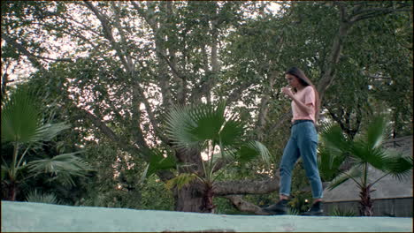 young girl model walking with tropical plants on background