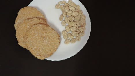 indian-traditional-sweet-tilkut-in-white-plate-with-black-background