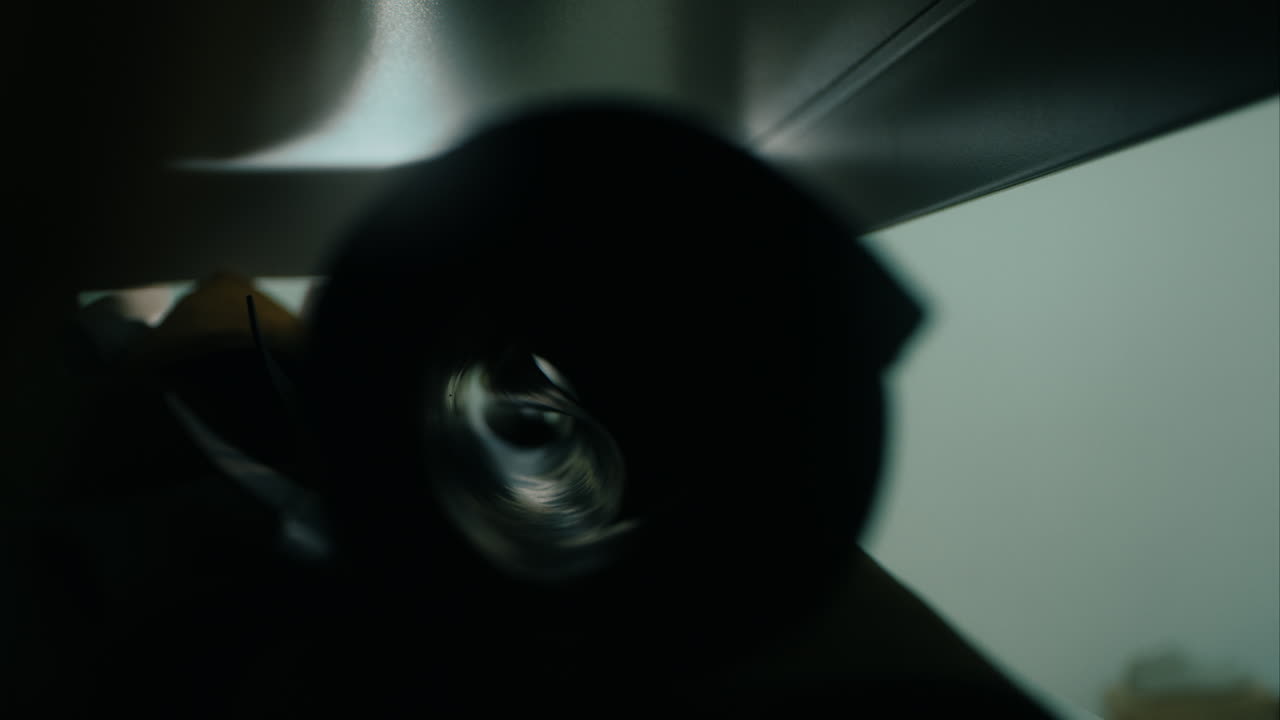 estante de taller con cuero. cerca de las manos del hombre tomando el rollo de cuero negro