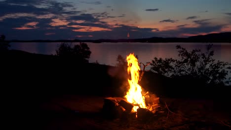 Philip-Edward,-Island,-Ontario,-Canada---The-campfire-and-lake-at-evening-time---Wide-shot