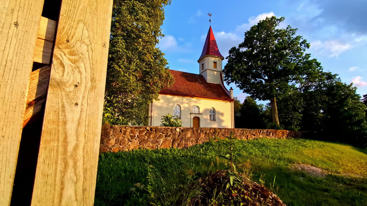 Small Countryside Church With Red Roof and Tower Surrounded by Summer Trees