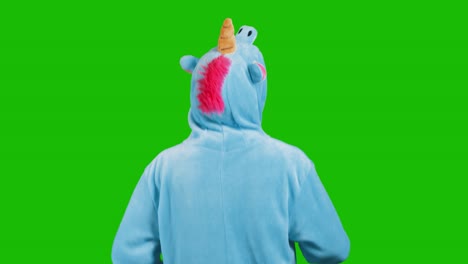 portrait of a cute young brunette girl in a beautiful unicorn costume on chrome key green background. smiling and playing. animator in costume. unicorn pajamas. 4k video with alpha channel