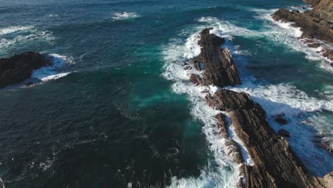 Ocean-waves-crashing-rocky-cliffs-on-Portugal-shore,-drone-aerial-view