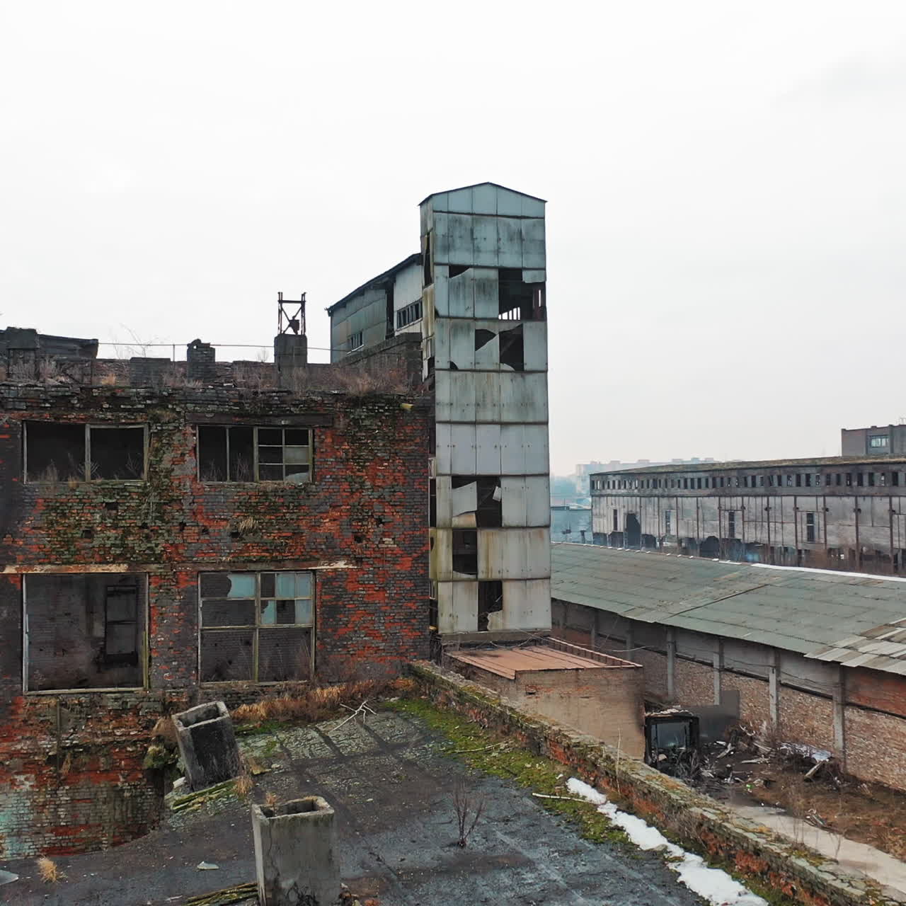 Abandoned factory with different buildings in industrial zone on the outskirts of the city? in aerial view.