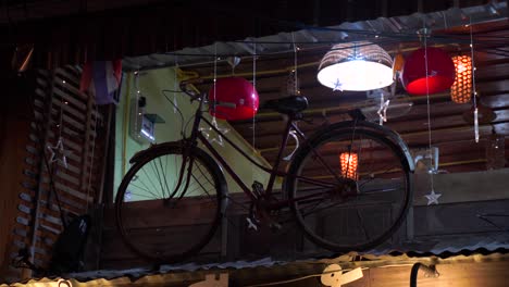 an old bicycle display in thailand background with christmas lights and ceiling lights over the roof of the house - close up shot