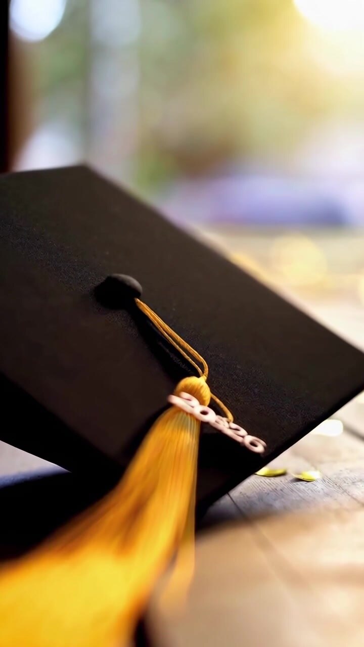 Tocco di laurea con nappa 2026 su superficie di legno.