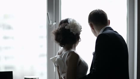 bridal pair looking out the window